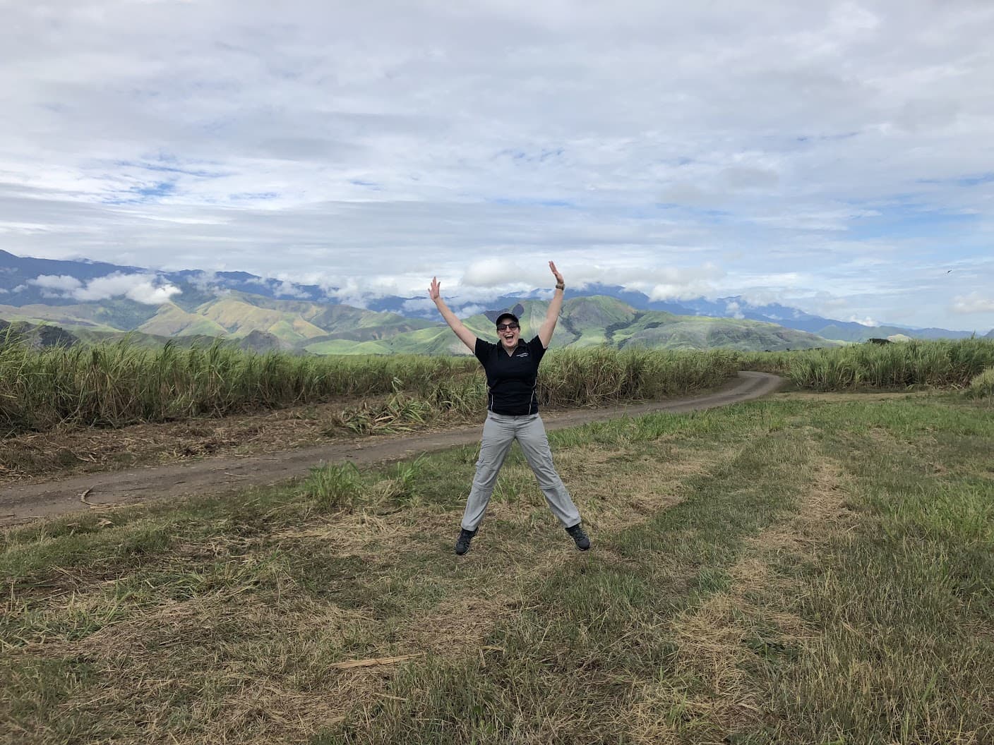 Renae Bice jumping in front of the sugar cane farm in PNG