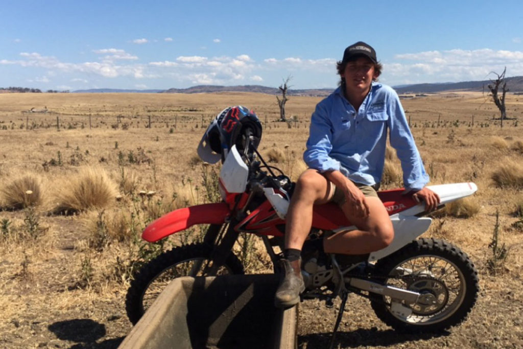 Will sitting on a motorbike in a large field