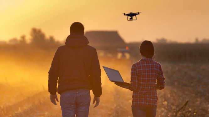 Farming couple with drone and iPad